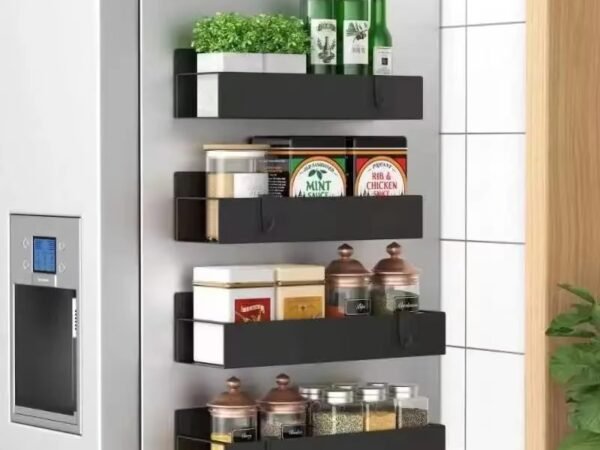 A heavy-duty, black magnetic refrigerator shelf holding several full spice jars and a bottle of olive oil on the side of a fridge.