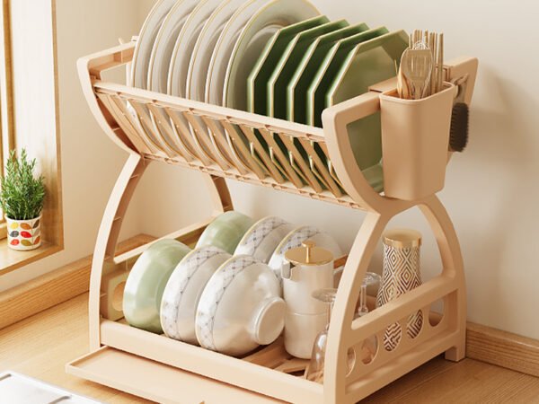 A multi-layer kitchen sink organizer rack sitting on a countertop, neatly holding bowls, chopsticks, and hanging utensils.