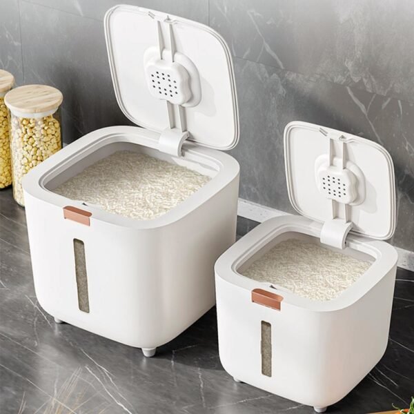 A white, modern airtight rice dispenser sitting on a kitchen counter, with the included measuring cup next to it.